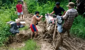 miris-kendaraan-roda-dua-tertahan-karena-ruas-jalan-rusak-sehingga-untuk-melintas-ruas-jalan-wa-yagung-long-umung-motor-harus-diangkat-OJcbP
