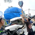 EVAKUASI KENDARAAN Petugas kepolisian bersama warga mengevakuasi Daihatsu Gran Max Pick Up yang ringsek setelah menabrak bagian belakang truk di Jalan Poros Bulu
