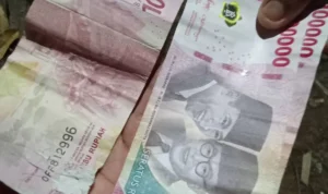 BEREDARWarga menunjukan uang palsu yang diupload di media sosial