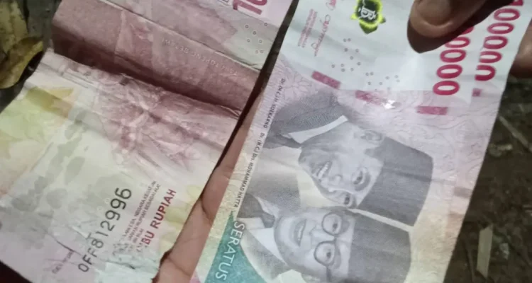 BEREDARWarga menunjukan uang palsu yang diupload di media sosial